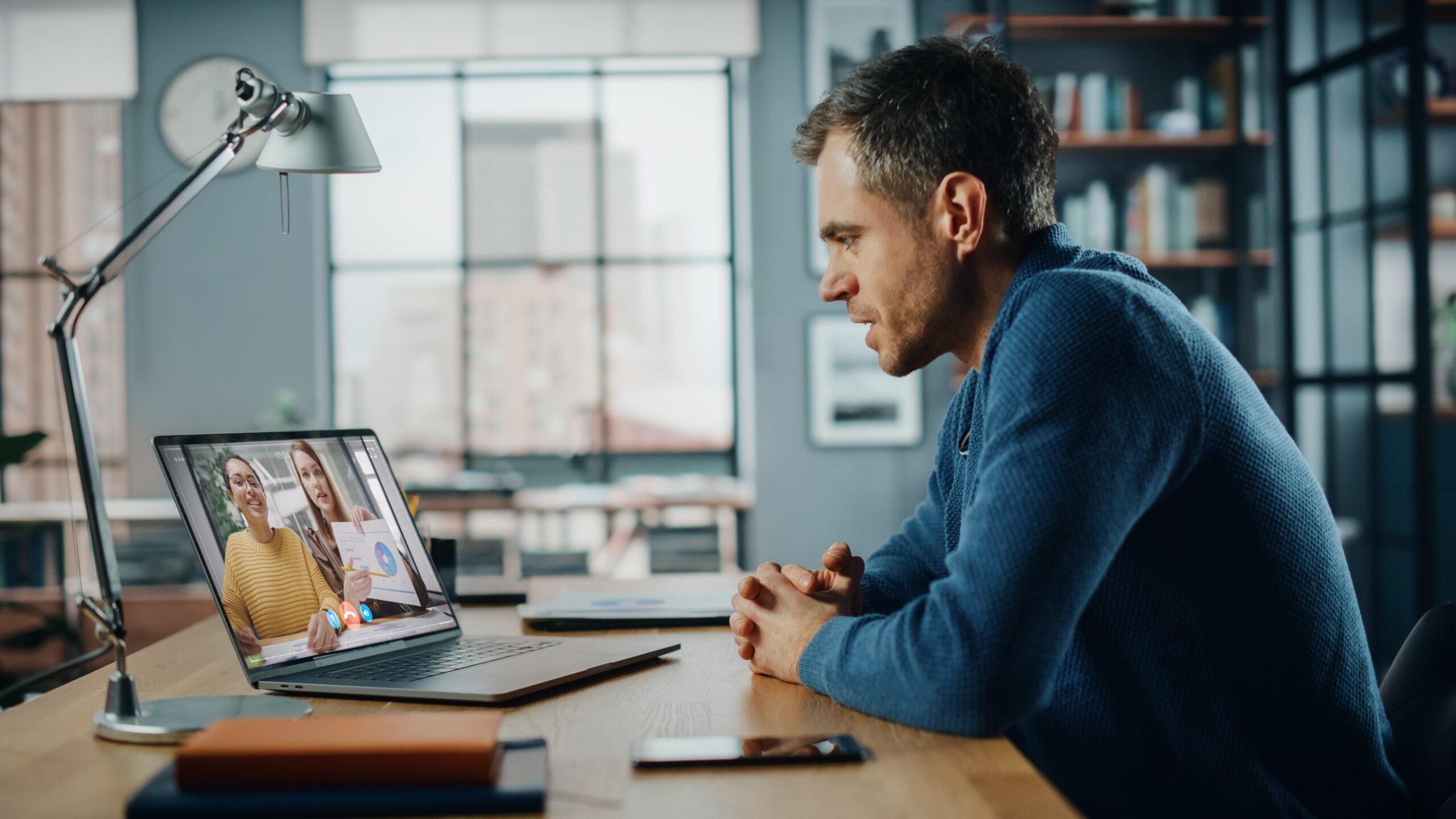 man-sits-desk-front-laptop-with-man-looking-screen-that-says-microsoft-it-scaled
